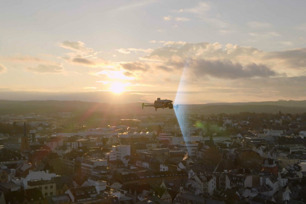 DJI enterprise drone flying above a populated urban area during a controlled operation.